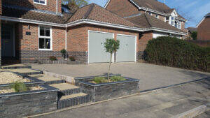 grey coloured resin driveway for home with grey garage doors